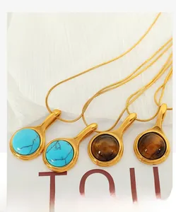 Detailed view of round turquoise and tiger eye stone pendants with 18K gold plated chains