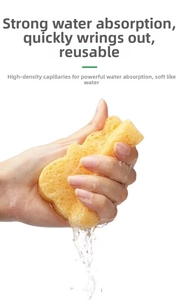 Close-up of hand squeezing yellow wood pulp baby bath sponge showing high water absorption
