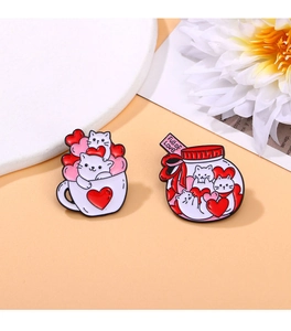Detail of pink kitty enamel pins featuring 'Full of Love' glass jar and cats in cups