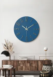 Detail of a minimalist 12-inch blue wall clock with gold 3D numbers in a home setting
