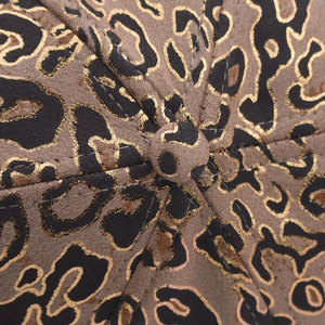 Detail of leopard print baseball cap featuring gold foil accents and faux suede texture