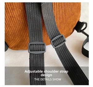 Detail of adjustable black nylon shoulder strap on brown corduroy backpack for women