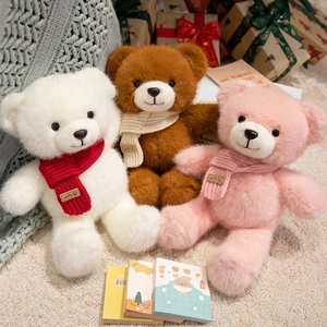 Three plush teddy bears in white, brown, and pink wearing smile scarves in a gift box