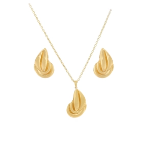 Detailed macro view of golden metal stylized leaf pendant and earring jewelry set