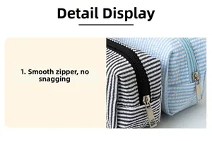 Close-up of smooth metal zipper detail on seersucker striped stationery organizer bag