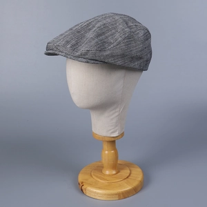 Classic herringbone patterned flat cap on a mannequin showcasing retro tweed texture