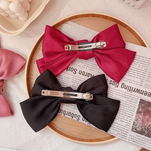 Oversized JK style plaid bow hair clips in red and black with metal spring fastener