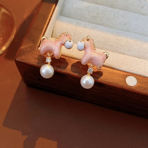 Detailed macro view of 18K gold plated horse earrings with elegant pearl and enamel accents