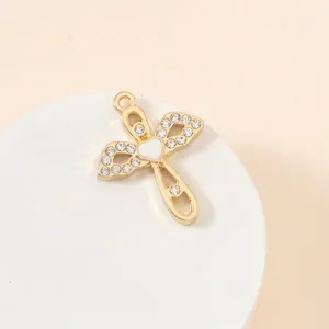 Macro detail of gold-plated cross and bow pendant with heart stone and pavé zircons