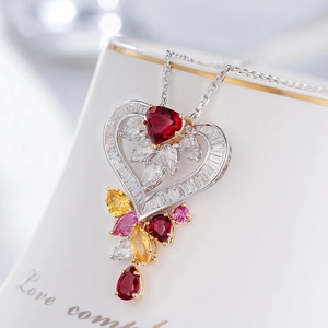 Macro detail of heart-shaped multi-color gemstone pendant with teardrop ruby accents