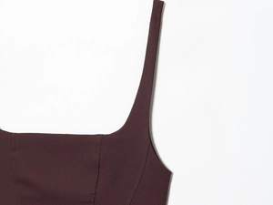 Detailed close-up of dark burgundy woven fabric with square neckline and fine stitching