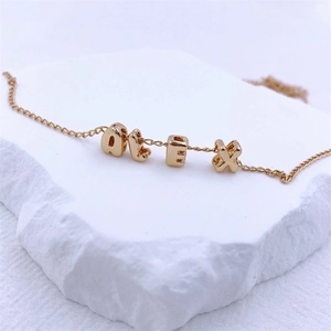 Golden personalized bracelet featuring ALEX letter bubble pendants on a fine chain
