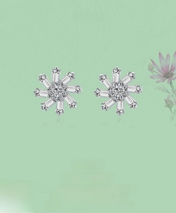 Detailed view of S925 silver snowflake earrings with cubic zirconia stones on floral background