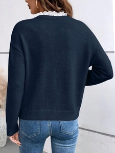 Detailed back view of navy blue knit sweater featuring delicate white lace trim on the collar