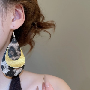 Close-up of leopard print and gold layered water-drop earrings on female model