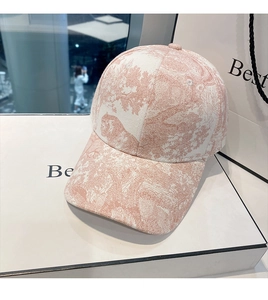 Detailed view of pink and white baseball cap with jungle animal print on a gift box