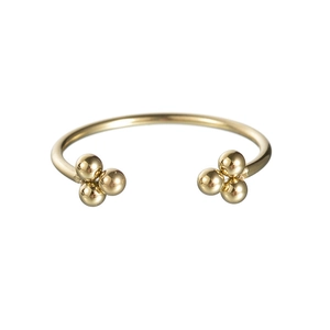 Dettaglio di un bracciale rigido regolabile dorato minimalista con piccoli grappoli di sfere