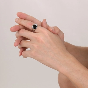 Macro view of polished silver steel ring featuring a round black enamel inlay