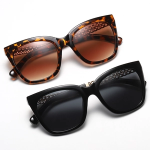 Oversized cat-eye sunglasses in black and tortoiseshell with gold metal chain temples