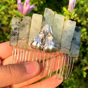 Detail of handmade wire wrapped hair comb with green crystals and silver bird skull