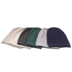 Flat lay of winter knit beanies in six colors including grey, beige, and navy blue