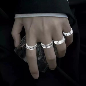 Close-up of four-piece silver titanium steel ring set with chain texture and Roman numerals