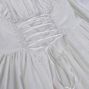 Detalle del vestido blanco de manga abullonada con encaje y cierre de cordón
