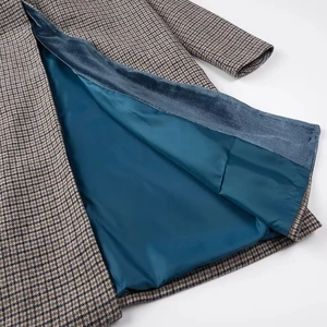 Détail d'un manteau en laine à carreaux avec tissu pied-de-poule brun et doublure bleue