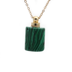 Detail of green malachite cylinder perfume bottle pendant with golden metal cap and chain