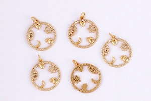Detail of five gold micro-pave pendants with heart, star, moon, palm, and eye motifs