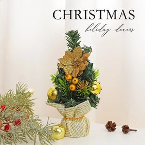 Mini tabletop Christmas tree with gold flowers and berries on a decorative base