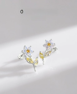 Dettaglio degli orecchini a fiore con petali di opale e zirconi gialli incastonati