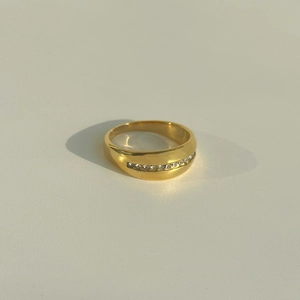 Macro shot of 18k gold plated titanium ring with single row of cubic zirconia stones