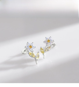 Dettaglio orecchini a fiore in argento 925 con petali di opale e gemme gialle