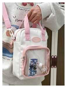 Detail of white and pink ita bag with a clear front window for anime pins and charms