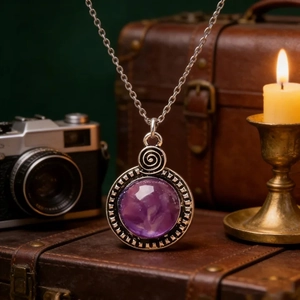 Gros plan du pendentif en résine violette avec monture en spirale argentée vintage