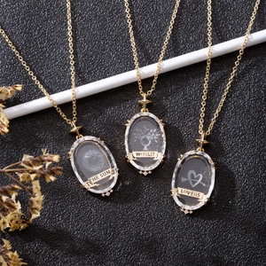 Vintage 18K gold plated tarot sun and moon crystal pendants on black leather background