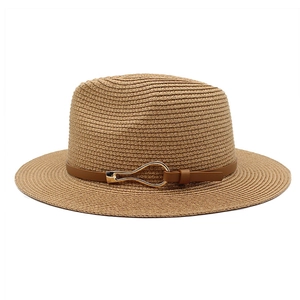Detail of straw fedora hat featuring fine weaving and brown leather band with gold buckle