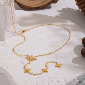 Detail der 18K Gold Stern-Halskette auf rustikaler Steinplatte mit Vintage-Dekor