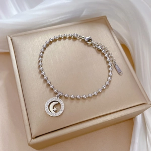 Macro detail of silver titanium steel bead bracelet with star and moon pendant