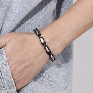 Detail of men's chunky titanium steel chain bracelet with black and silver link design
