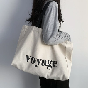 Minimalist canvas tote bag with Voyage print shown on a model for travel and yoga