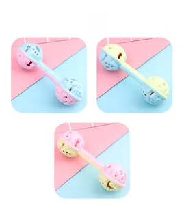 Close-up of macaron-colored baby dumbbell rattles with hollow balls and interior bells