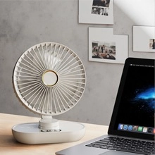 Close-up of a white mini USB cat fan on a wooden desk with laptop background