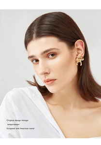 Detail of vintage gold bow earrings on a model showing retro style and metal texture