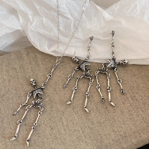 Detailed close-up of dark style silver skull jewelry set including necklace and earrings