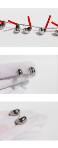 Detail shot of silver bean earrings held by a gloved hand showing scale and size