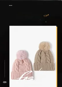 Dettaglio della maglia dei berretti invernali rosa e beige con pompon in finta pelliccia
