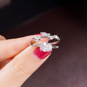 Detalle macro de anillos apilables de plata con gema ovalada y piedras en forma de hoja