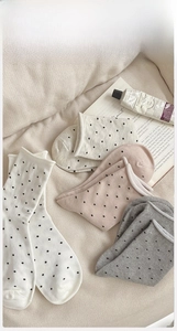 Detail of four-color polka dot crew socks made of premium combed cotton on cozy background